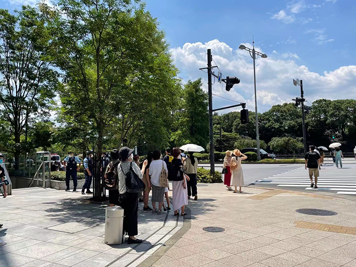7月23日，东京皇居附近的街角，手持照相机等待拍摄蓝色脉冲飞行表演队的人群。（人民网 吴颖摄）
