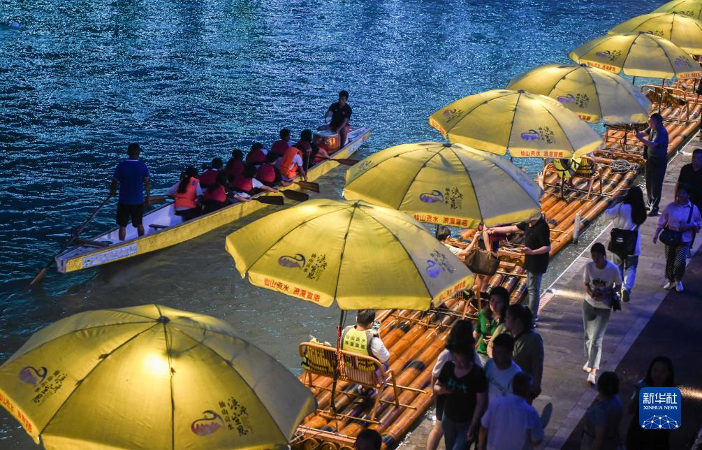 8月18日，龙舟爱好者在贡水河里进行夜间训练。新华社记者 程敏摄