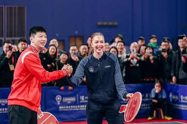 奥运冠军、乒乓球畅通员马龙（左）与瑞典闻明乒乓球畅通员克里斯蒂娜·卡尔伯格（右）进行扮演赛。支配方供图