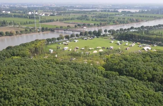 在上海松江区一处营地，市民旅客在河滨草地上搭起帐篷。（2023年9月29日，无东说念主机像片）。新华社记者 方喆摄