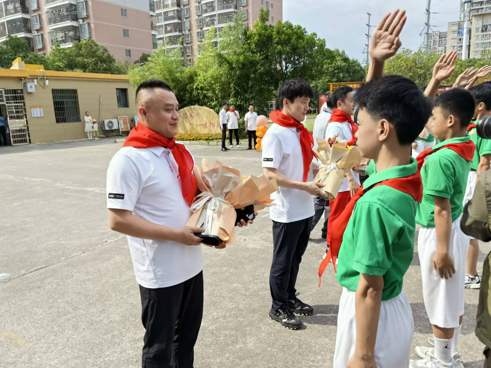 瑞金金穗学校学生为彭勃（左一）等奥运冠军佩戴红领巾�	
、人民网记者 杨磊摄