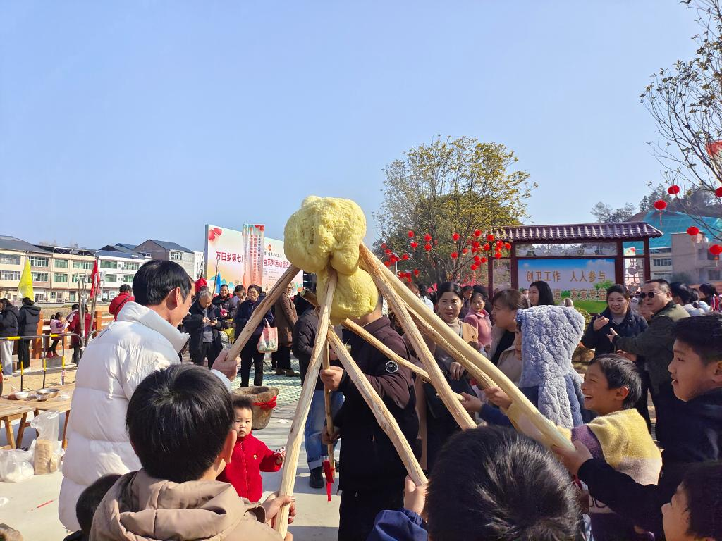 1月1日，江西瑞金万田乡，旅客体验打黄元米粿。新华社记者刘佳敏 摄