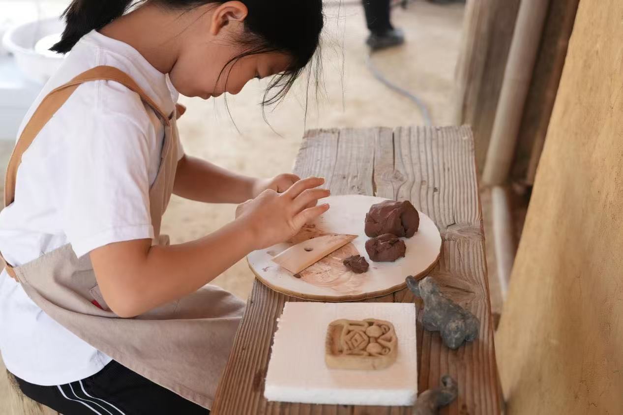 游客制作良渚特色陶艺品。良渚博物院供图