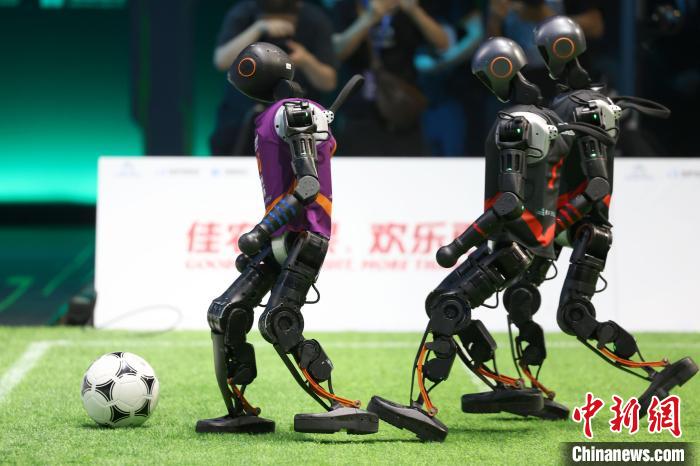 6月28日晚，2025RoBoLeague机器人足球联赛总决赛在北京打响。图为清华大学火神队(紫)对战北京信息科技大学Blaze光炽队(黑)。中新社记者 富田 摄
