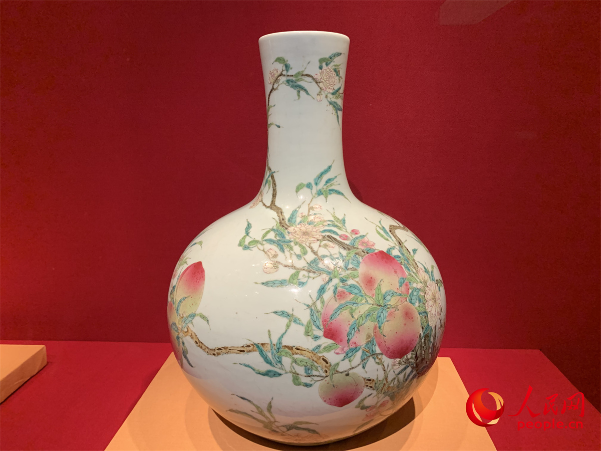 “百年守护——从紫禁城到故宫博物院”展览展出的粉彩九桃结树图天球瓶。人民网记者 刘微摄