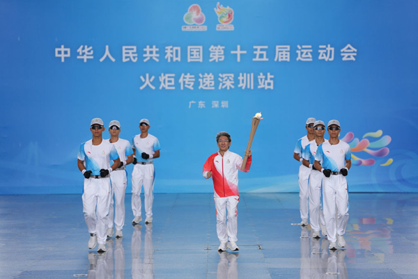 火炬手薛其坤（中）手持火炬起跑。新华社记者 江汉 摄