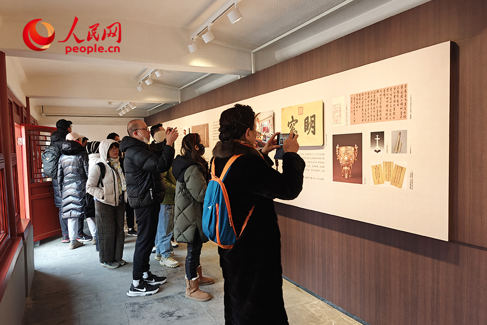 游客在养心门外东西值房了解养心殿历史沿革和保护。人民网记者 韦衍行摄