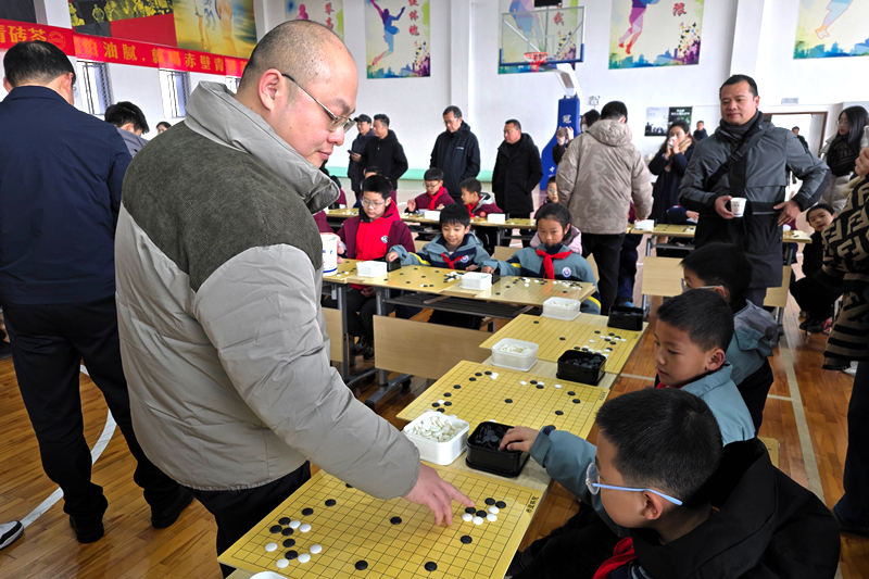 唐韦星九段与学生下指导棋。