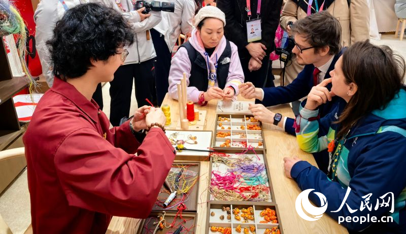 外国游客体验中国传统结绳技艺。