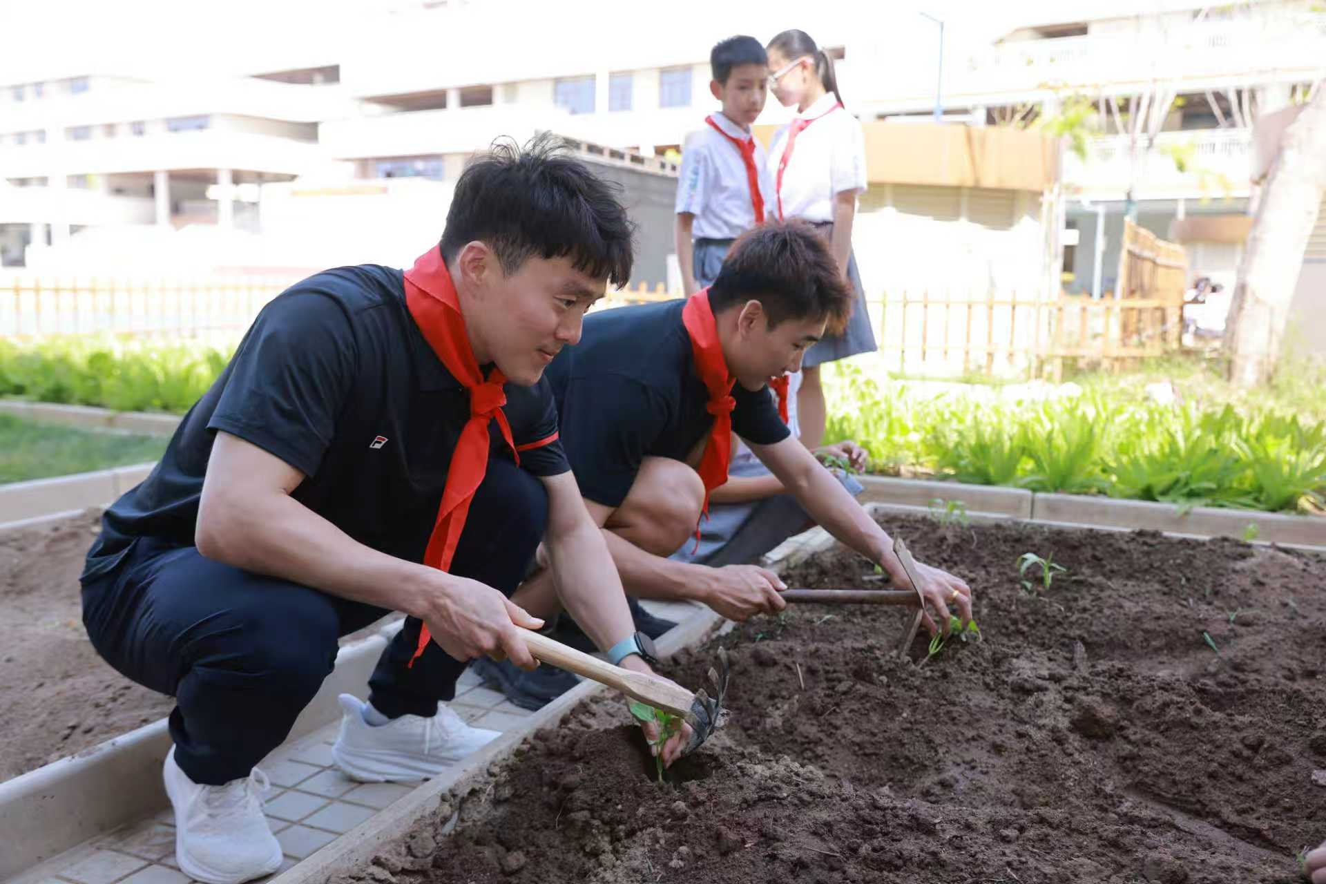 齐广璞(左一)与高亭宇在校园内播种育苗。活动主办方供图