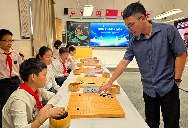 中国台北棋手赖均辅九段与学生下指导棋。