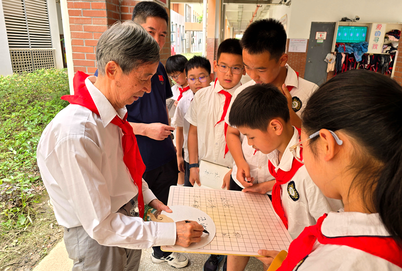 中国围棋协会名誉主席王汝南为学生签名。