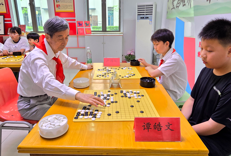 中国围棋协会名誉主席王汝南与学生下指导棋。