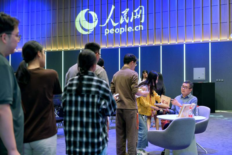 活动结束后，丁捷为青年职工签名赠书。人民网记者 任峰涛摄