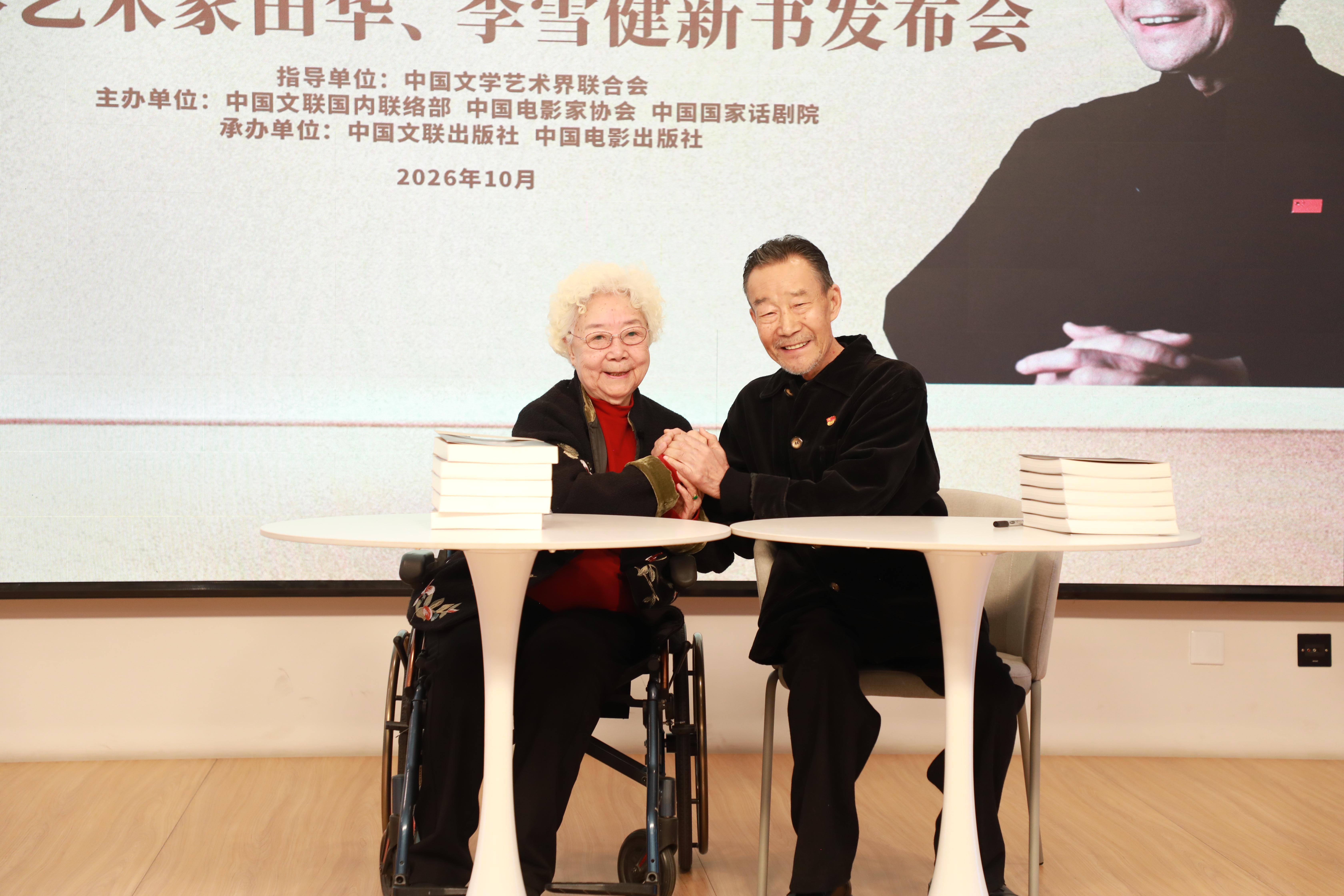 发布会现场，田华与李雪健紧握双手。中国文联供图