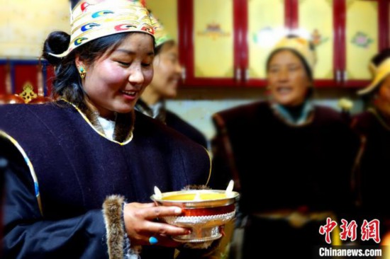 图为藏族姑娘向客人敬酒。　冉文娟 摄