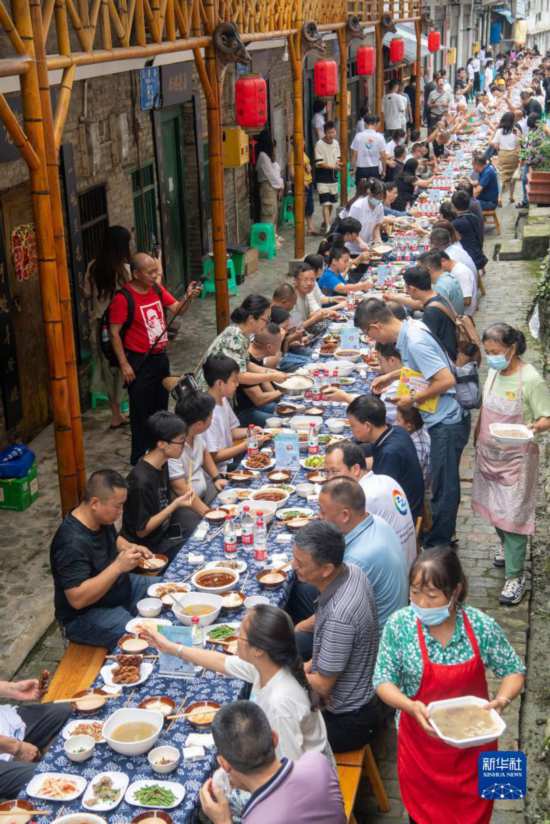 7月29日，民俗在重慶市綦江區安穩鎮，鄉村人們在“苗家伏羊節”上吃長桌宴。重慶助力振興新華社記者 唐奕 攝