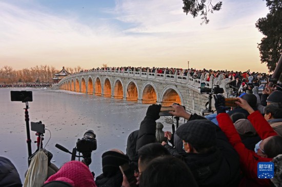 12月22日，游客邪在颐战园拍摄“金光脱洞”光景。