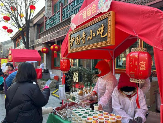 1月29日，游客在北京厂甸庙会购买特色小吃。新华社记者 杨淑君 摄