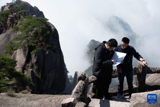 2025年4月23日，黄山风景区文化事业管理办公室副主任俞杨阳（右）与同事盛泽洋在封闭轮休中的莲花峰记录沿途石刻文物信息。