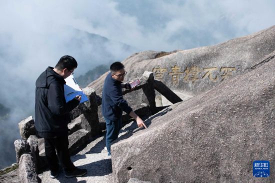 2025年4月23日，黄山风景区文化事业管理办公室副主任俞杨阳（右）与同事盛泽洋在封闭轮休中的莲花峰记录沿途石刻文物信息。