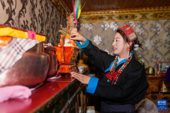 在阿里地区普兰县科迦村,加央卓玛在摆放“切玛”(五谷丰登斗)(12月18日摄)。新华社记者 丁增尼达 摄