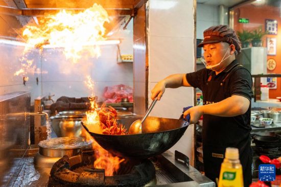 5月15日，在湖南南县沿湖路一家餐饮店，厨师烹饪小龙虾。